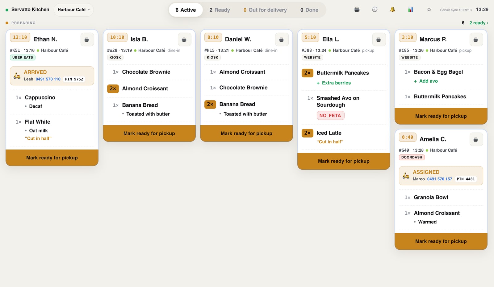 Servatto Kitchen with demo shop: customer names, timers, the order source, the assigned delivery driver, items with modifiers, and Mark ready for pickup buttons.